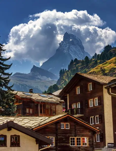 Matterhorn surrounded with clouds in front of Zermatt village houses by day, Zermatt, Switzerland