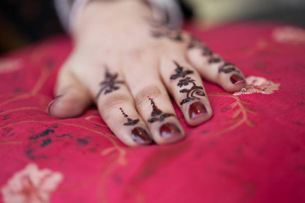 A close up of and Asian Woman’s hand being painted with Henna at the festival of Eid al-Fitr