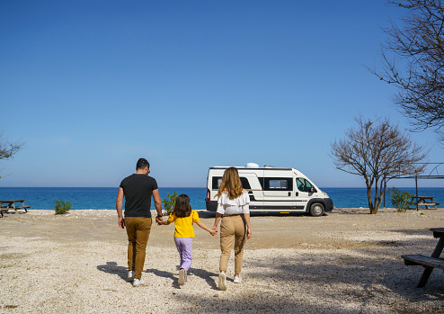 Family with one child having fun at a caravan vacation near the beach