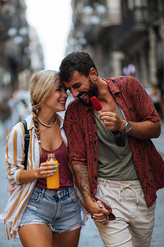 Affectionate young couple exploring a new city by walking through the streets