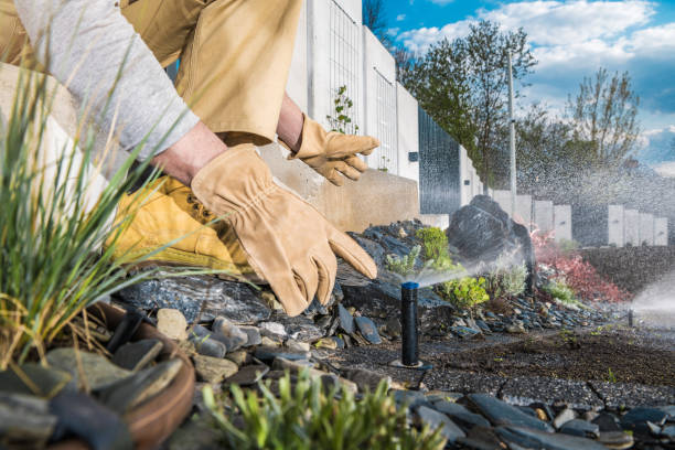 Automatic Backyard Garden Lawn Sprinkler Installation Automatic Backyard Garden Lawn Sprinkler Installation and Adjusting Performed by Professional Garden Technician. Close Up Photo. sprinkler stock pictures, royalty-free photos & images