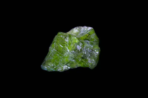 Raw green Peridot from Pakistan on black background. Weight 4.16 grams (20.8 carats). Photographed on black background.
