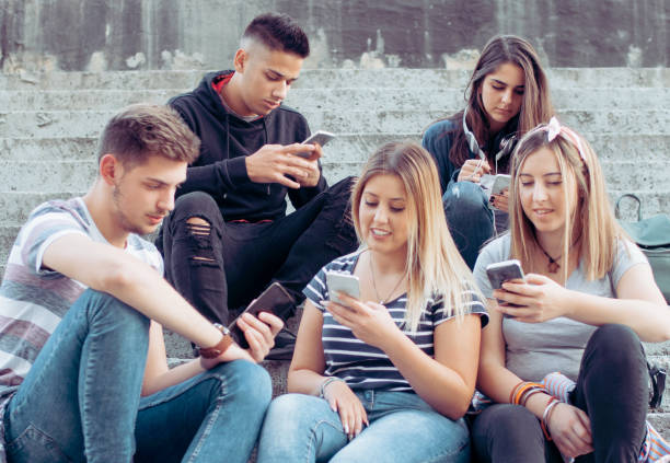istock Internet addiction, young people looking at their smart phones 1394856266