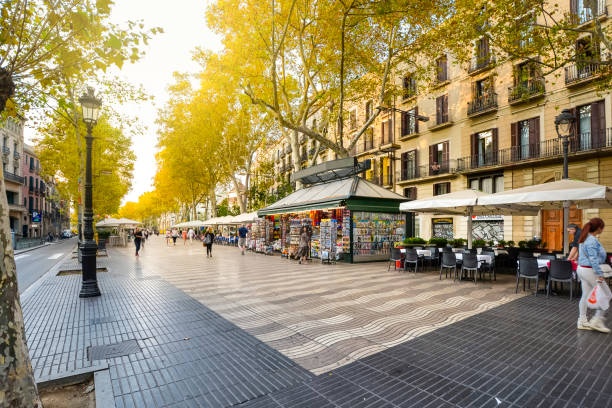 tôt le matin sur le boulevard piétonnier las ramblas à travers l’historique barcelone espagne alors que les touristes et les habitants passent par des kiosques, des boutiques, des cafés et des kiosques à journaux. - avenue photos et images de collection