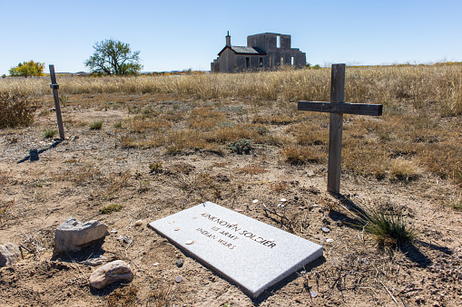 A cross marks the grave of an unknown soldier who fought and died in the Indian Wars near Fort Laramie Wyoming along the Oregon Trail
