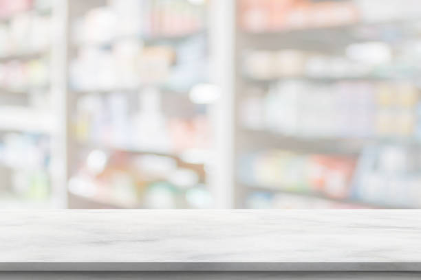 istock Empty white marble counter top with blur pharmacy drugstore shelves background 1394859108