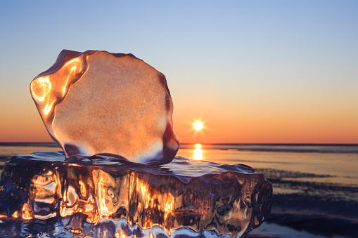 Floes of pure ice of Baikal lake in Siberia. Early morning. Sunrise. Winter, ecology or travel concept. Copy space for text.