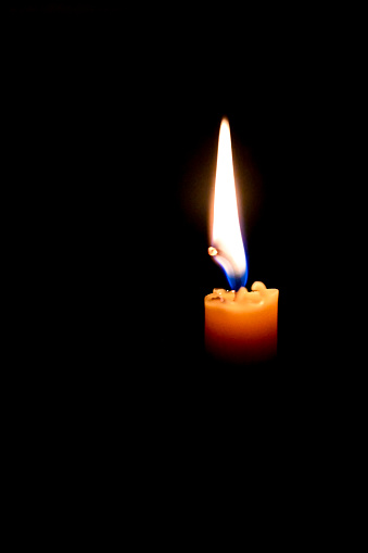 Single candle in the dark