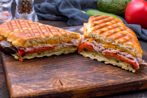 ハムとチーズのサンドイッチとボード上の野菜を暗い石のテーブルマクロクローズアップ - toasted sandwich close up color image panini ストックフォトと画像