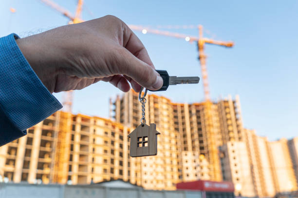 key in hands against the background of construction of a modern building key in hands against the background of the construction of a modern building industrial music stock pictures, royalty-free photos & images