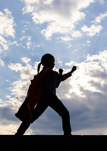 Brave kid silhouette in the air at twilight in Canary Islands, Spain. No fear, courage, dare concepts