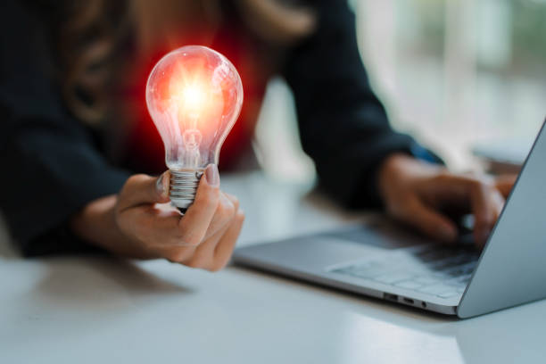 istock Hand holding a light bulb. Innovative and inspirational concepts looking for new ideas for designing, working better with innovation and saving energy. 1394880009