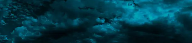 Photo of Heavy gloomy dull thunderclouds. Dark teal dramatic night sky. Storm. Toned cloudy sky background with space for design.