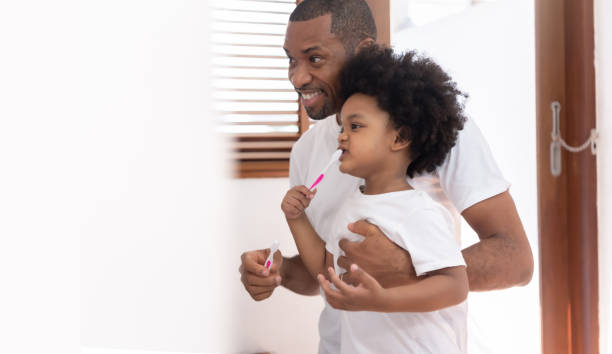 istock African American father and son brushing teeth. 1394881709