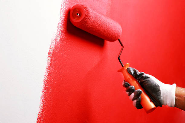 malarz maluje wewnętrzną ścianę na czerwono - paint brushing house painter wall zdjęcia i obrazy z banku zdjęć