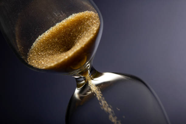istock Hour Glass with running sand inside, on blue background. Time passing or countdown concept. 1394884307