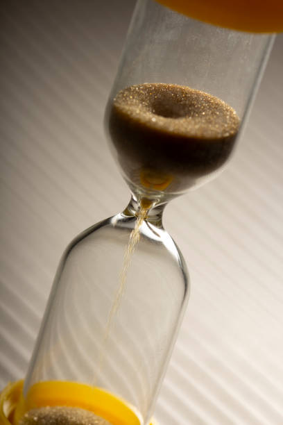 istock Hour Glass with running sand inside, on grey background. Time passing or countdown concept. 1394884315