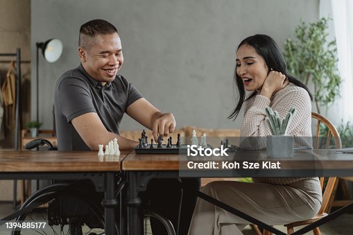 istock Friendship beyond disability - A man and woman playing chess together 1394885177