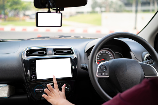 Woman driving and finger touching screen in car. woman sitting in a car with her finger touching electronic controls.