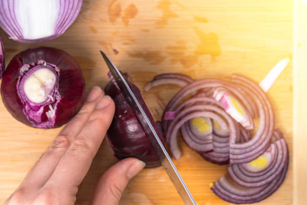 istock Cook cuts purple onion, top view 1394886882