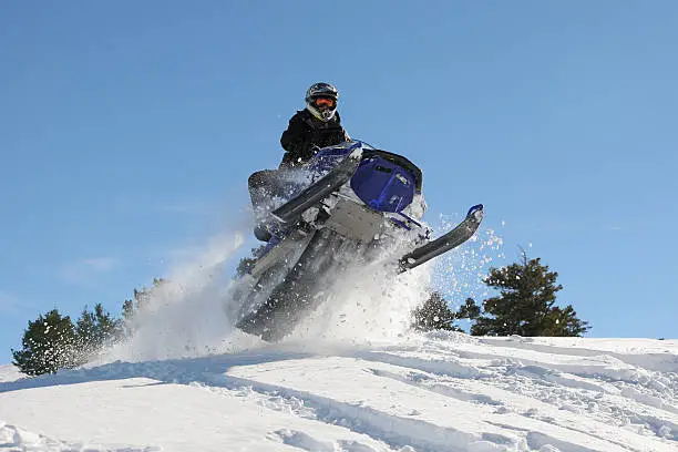 man jumping a snowmobile high into the air