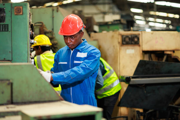 istock Black Male Engineer Working on machine in Factory. black man engineer checking Quality control the machine. Service and Maintenance of factory machinery. American African people. 1394890517