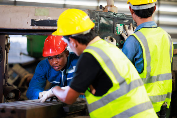 Training trainee concept. Yang male african american engineer explain the procedure for using the correct metal machine at factory.