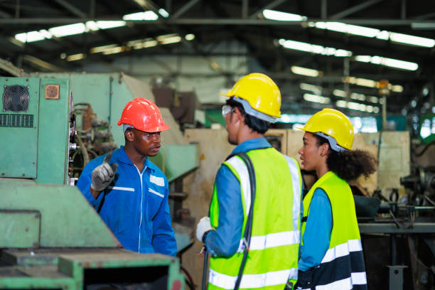 istock Training trainee concept. Yang male african american engineer explain the procedure for using the correct metal machine at factory. 1394890541