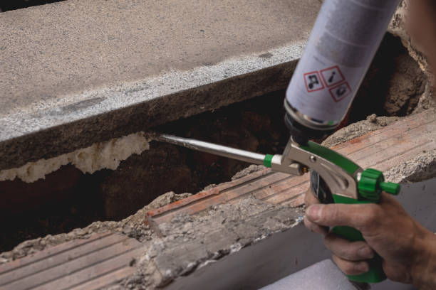 istock Person operating expandable foam gun while installing new window 1394890712