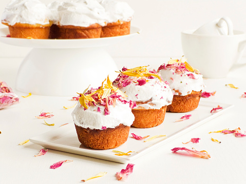 Cupcakes with whipped cream and edible fllowers. Shallow dof.