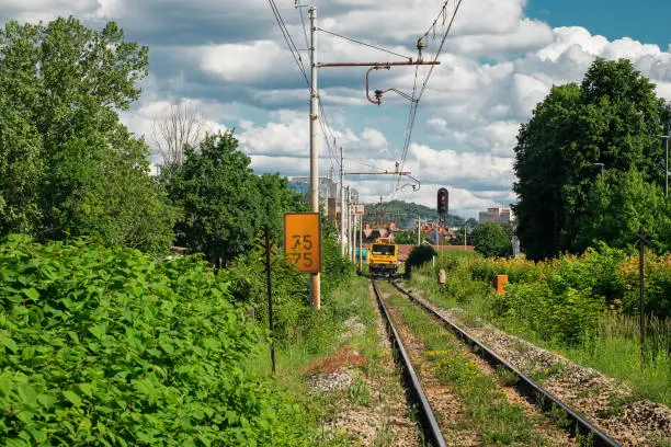 Train track under maintenance. Service of catenary on a mainline train track on a summer day.