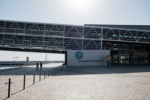 Lisboa , Portugal; 30 April 2022: General view of the Lisbon Oceanarium,Two people are walking under the building