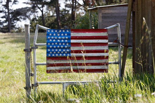 American flag on fence in field made of metal