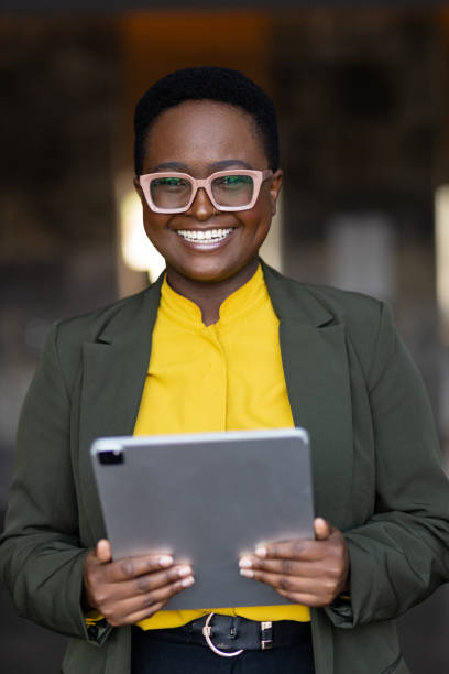 istock Smiling young black woman holding tablet 1394895593