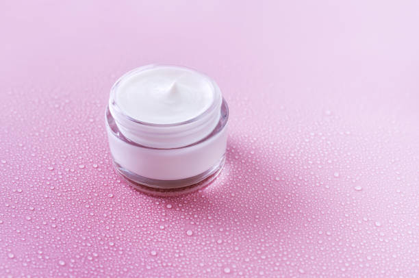 istock cream jar on pink background with water drops 1394898436