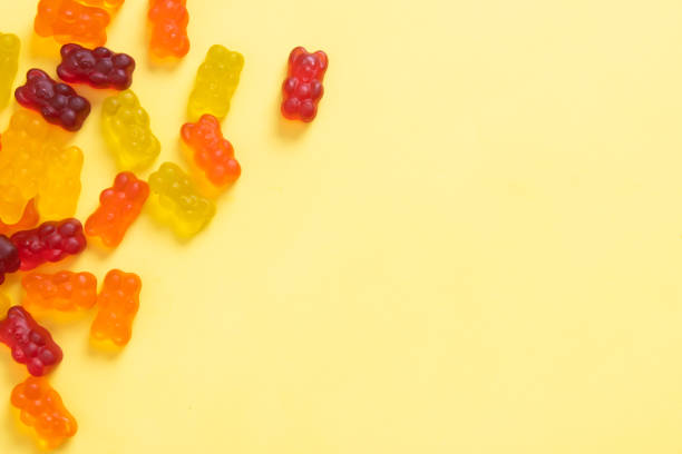 istock Colored jelly bears on an yellow background with copy space. Top view 1394899556