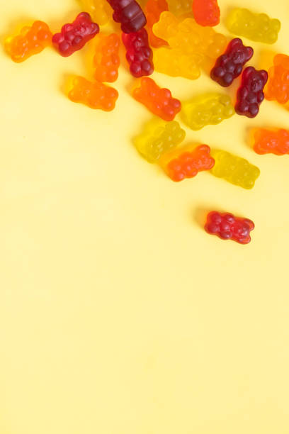 istock Colored jelly bears on an yellow background with copy space. Top view 1394899660