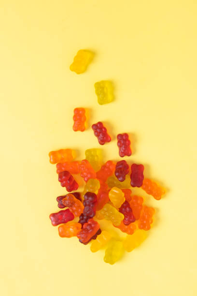 istock Colored jelly bears on an yellow background. Top view 1394899772