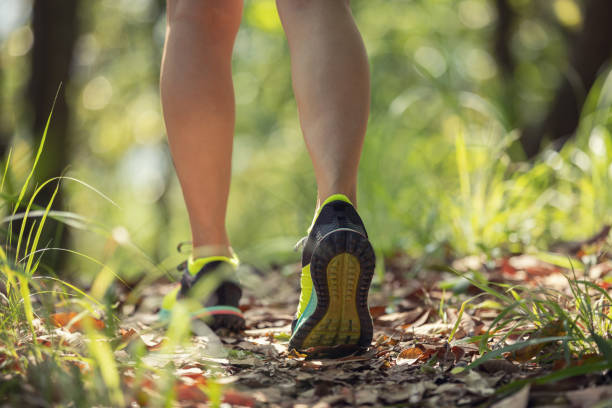 istock Woman runner running on forest trail 1394901265