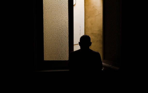istock Adult man looking through window in room 1394901378