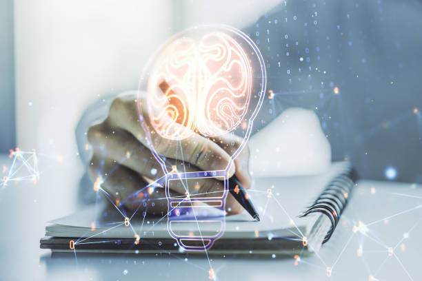 Creative light bulb with human brain hologram and with man hand writing in notepad on background, artificial Intelligence and neural networks concept. Multiexposure stock photo