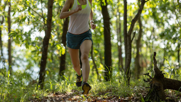 istock Woman runner running on forest trail 1394902069