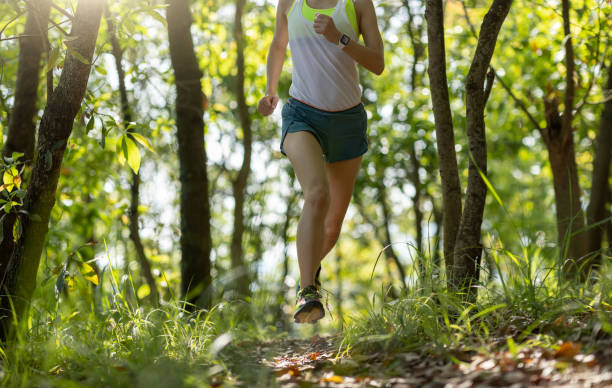 istock Woman runner running on forest trail 1394902150