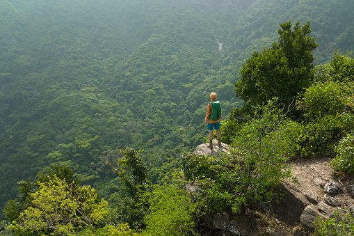 Aerial view of successful hiker enjoy the view on mountain top cliff edge