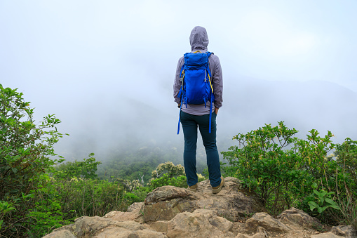 Successful hiker enjoy the view on mountain top cliff edge