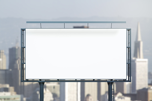 Blank white horizontal billboard on city buildings background at daytime, front view. Mockup, advertising concept