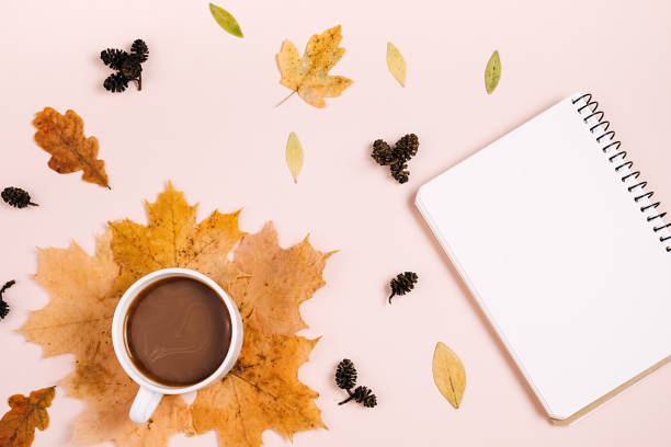 istock Flat lay composition with dry maple leaves, notebook and coffee latte cup on pink color background wall in studio. Creative autumn, thanksgiving, fall, halloween concept. Top view, copy space 1394904751