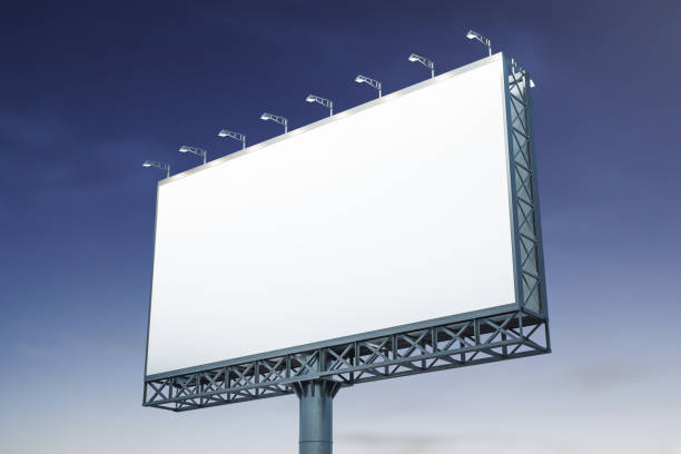 istock Blank white billboard on blue sky background at evening, perspective view. Mockup, advertising concept 1394904993