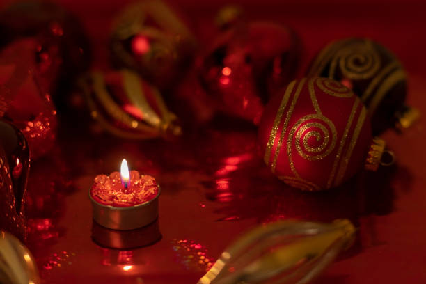 Christmas with red candles and christmas tree balls and green fir branches and pine cones