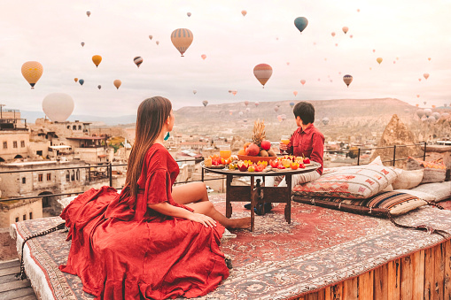 Viaje en pareja en Capadocia Coloridos globos aerostáticos volando sobre el valle a la hora del amanecer con un destino especial de viaje de desayuno en Turquía photo